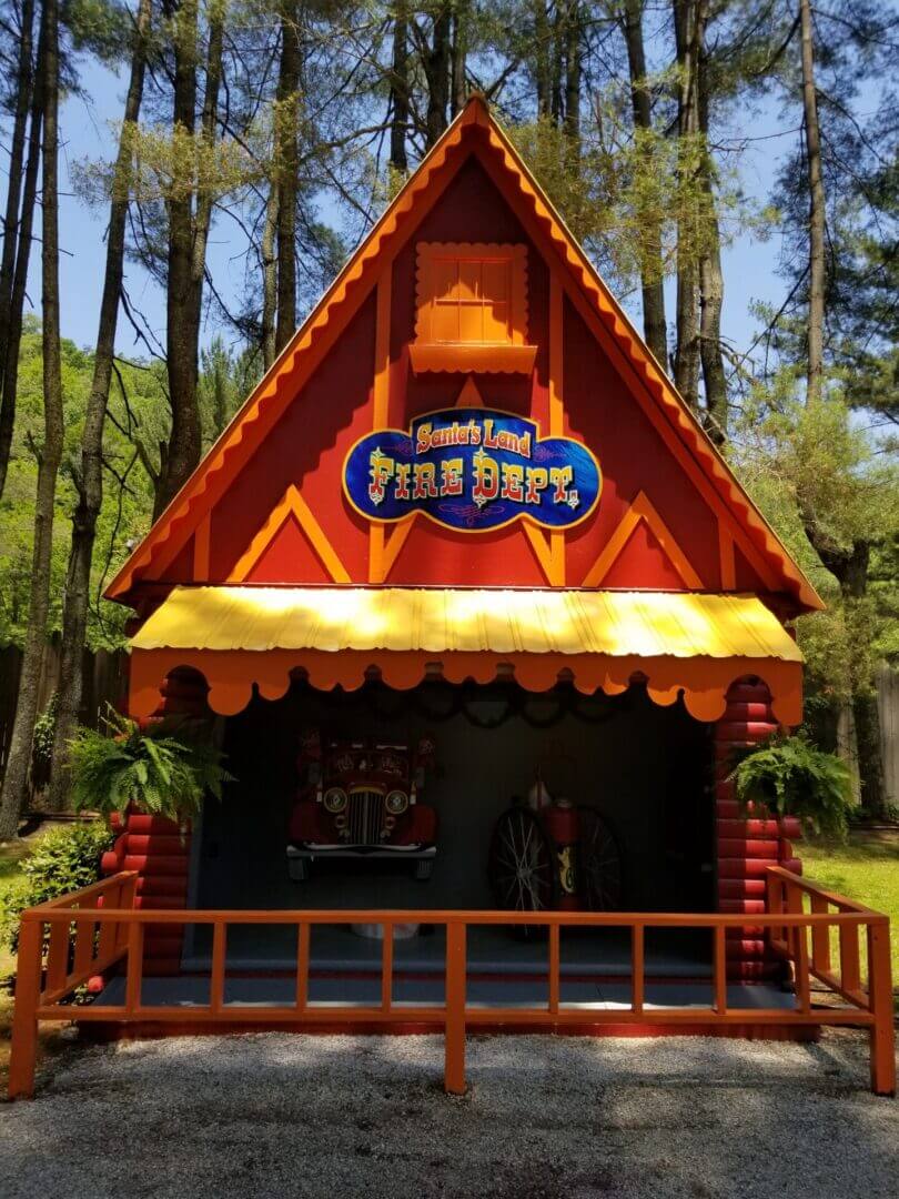 Colorful wooden puppet theater in a park with a bright orange roof.
