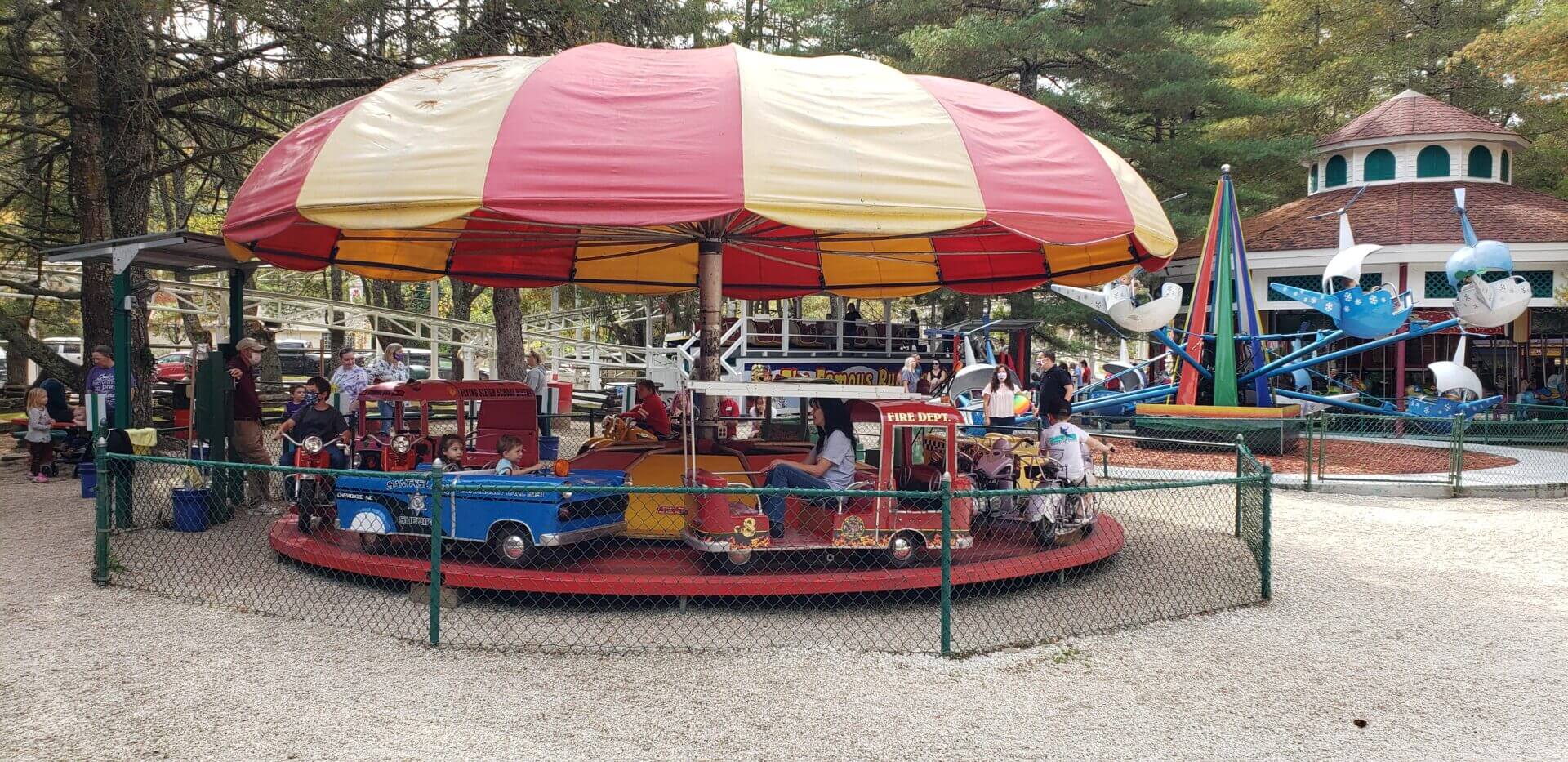 Children enjoying a colorful carousel ride at a park.