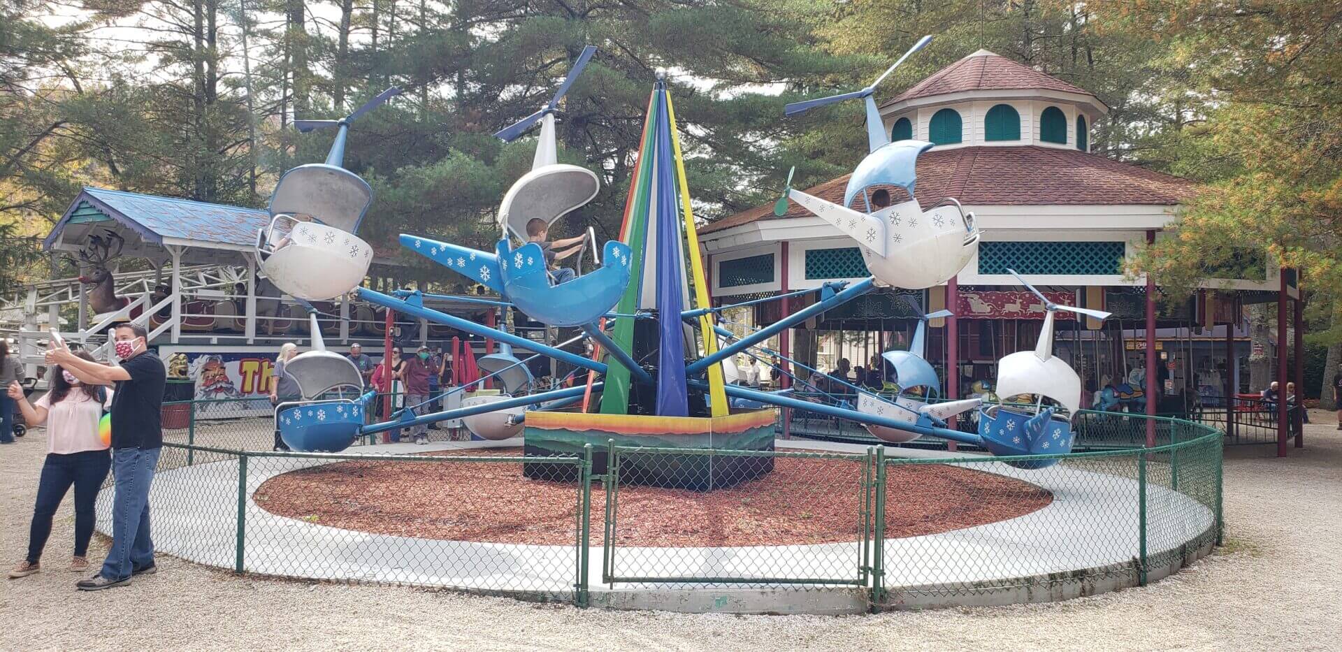 Children enjoying a ride on flying elephant swings at an amusement park.