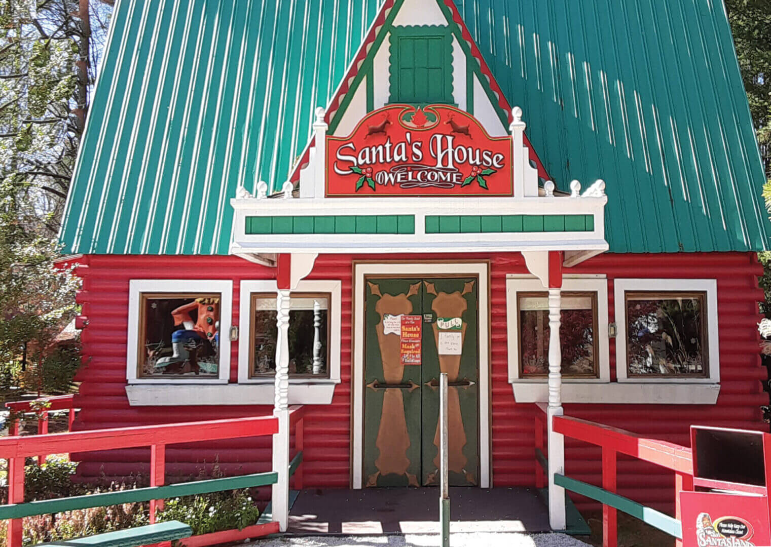Festive storefront of Santa's House with Christmas decorations and a welcoming entrance.