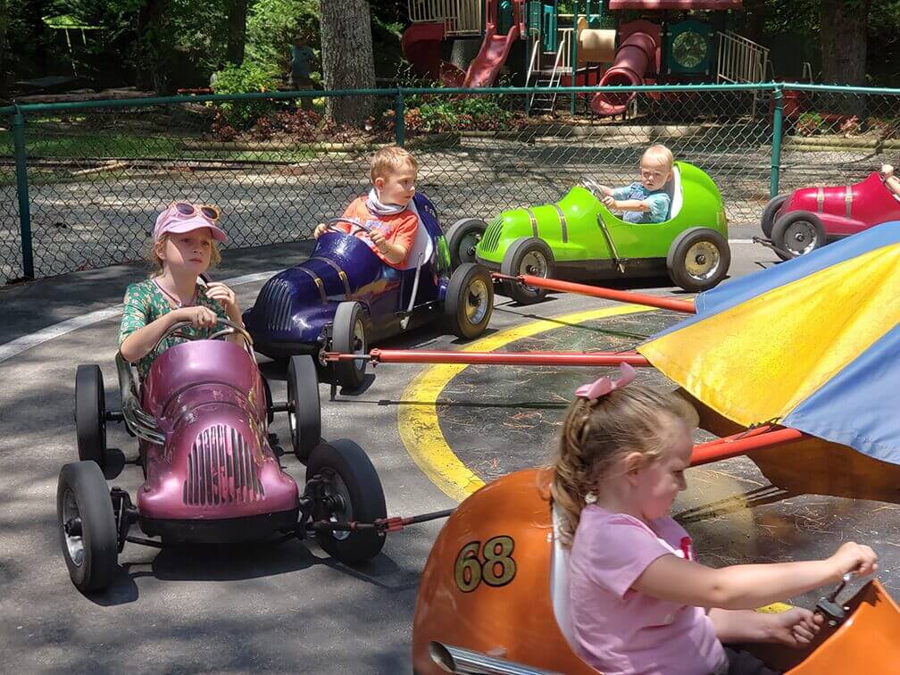 Group of kids in colorful pedal cars